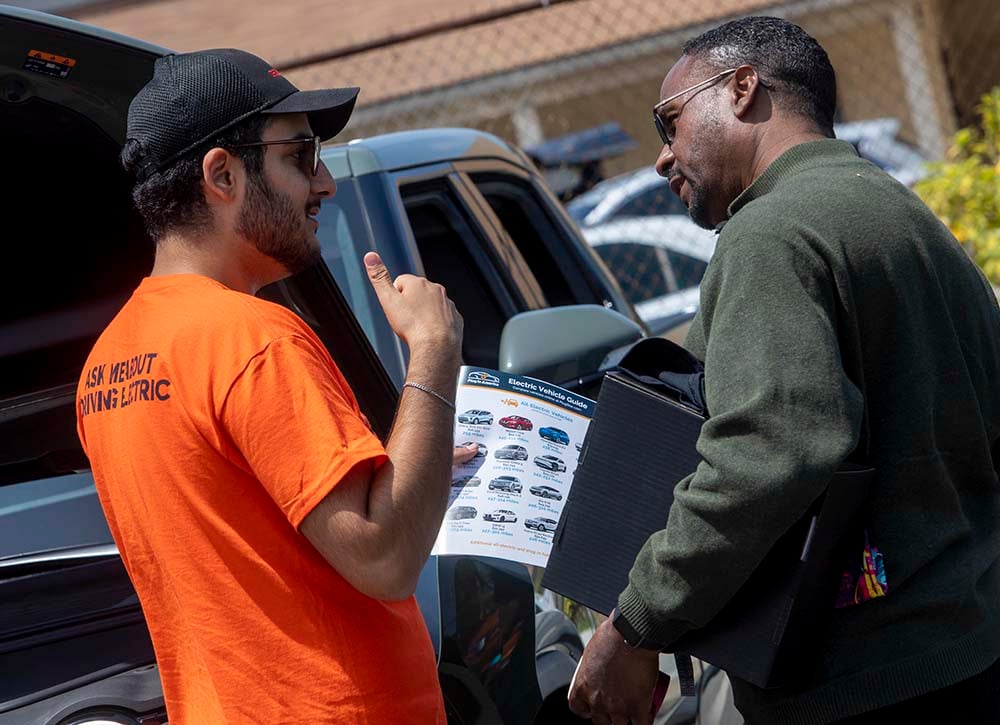 EV driver talking to another man about driving electric
